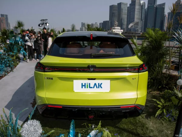 Many people gathered around the Deepal S7 yellow electric car taking pictures and observing it.