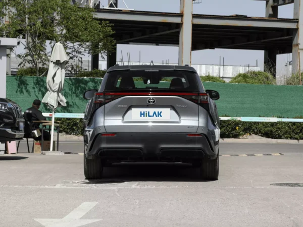 A close-up view of the rear of a gray Toyota BZ4X electric car, next to a sunshade and crew.