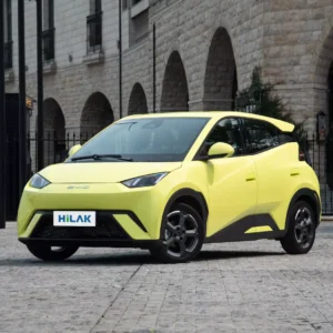 Left front view of a yellow BYD Seagull electric car with a black iron fence in the background.