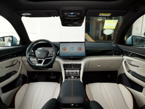 A detailed view of the interior of the cab of a BYD Song Plus electric car with a display next to the steering wheel and trim colors of gray and black.