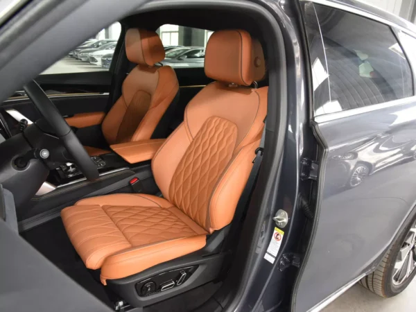 Detailed image of a BYD Tang electric car with driver's door open and seats using orange trim.