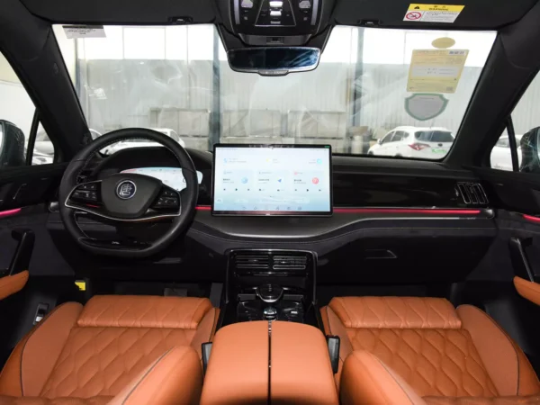 Detailed image of the cab of a BYD Tang electric car with a large screen on the right side of the steering wheel and seats using orange trim.