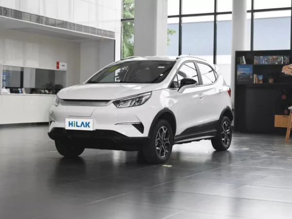 Close-up view of the left front of a white BYD Yuan Pro electric car with bookshelf next to it.