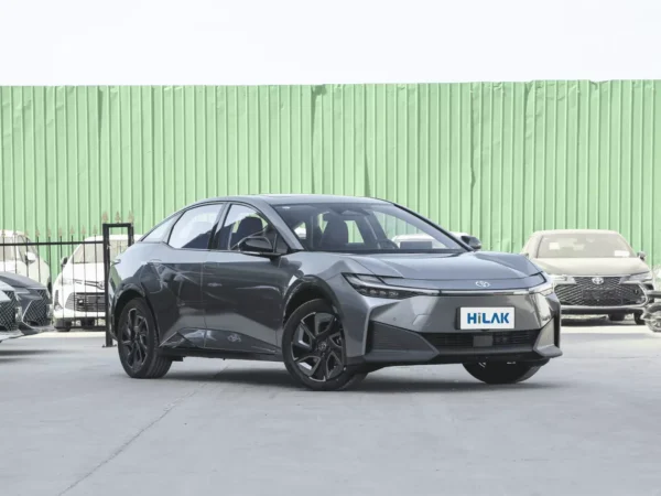 Right front view of a grey Toyota BZ3 electric car with a green wall in the background.