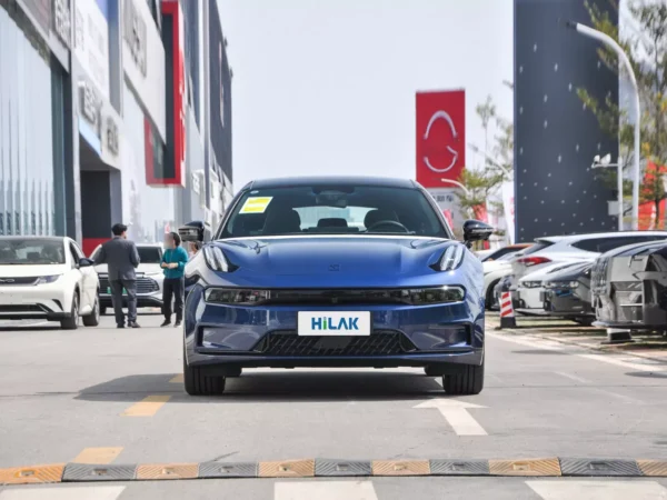 A picture of a blue ZEEKR 001 electric car parked on the curb of a shopping mall.